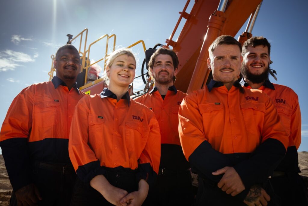 Five Western Australian Apprentices posing for a photo in front of a crane